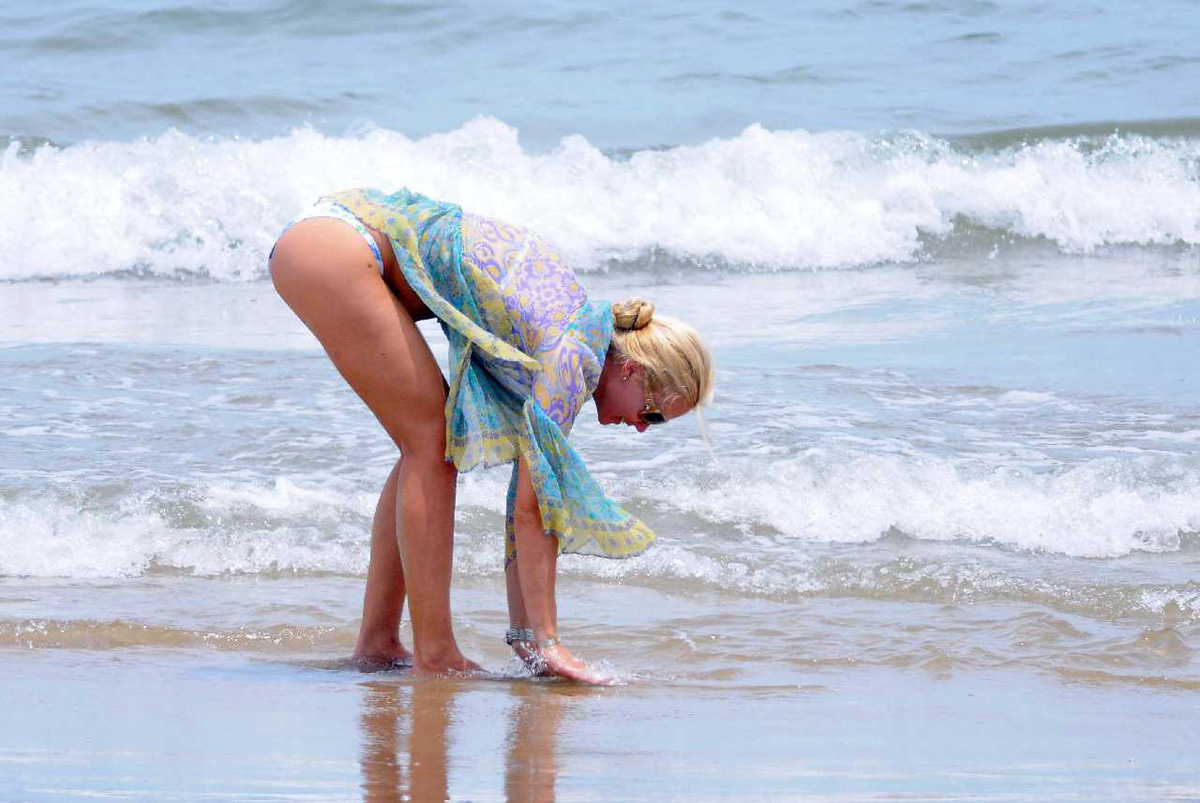 Девушка переодеваясь на пляже показала красивую грудь