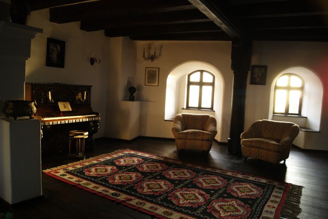 Гостиная комната в замке Бран с пианино и ковром ручной работы